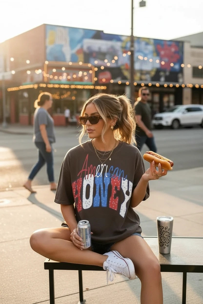 Southern Charm Design Works American Honey graphic t-shirt with distressed red, white, and blue lettering on a dark grey cotton tee.