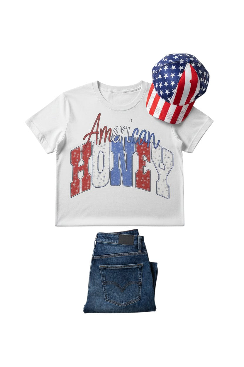 Southern Charm Design Works white cotton t-shirt with distressed "American Honey" graphic in red, white, and blue.
