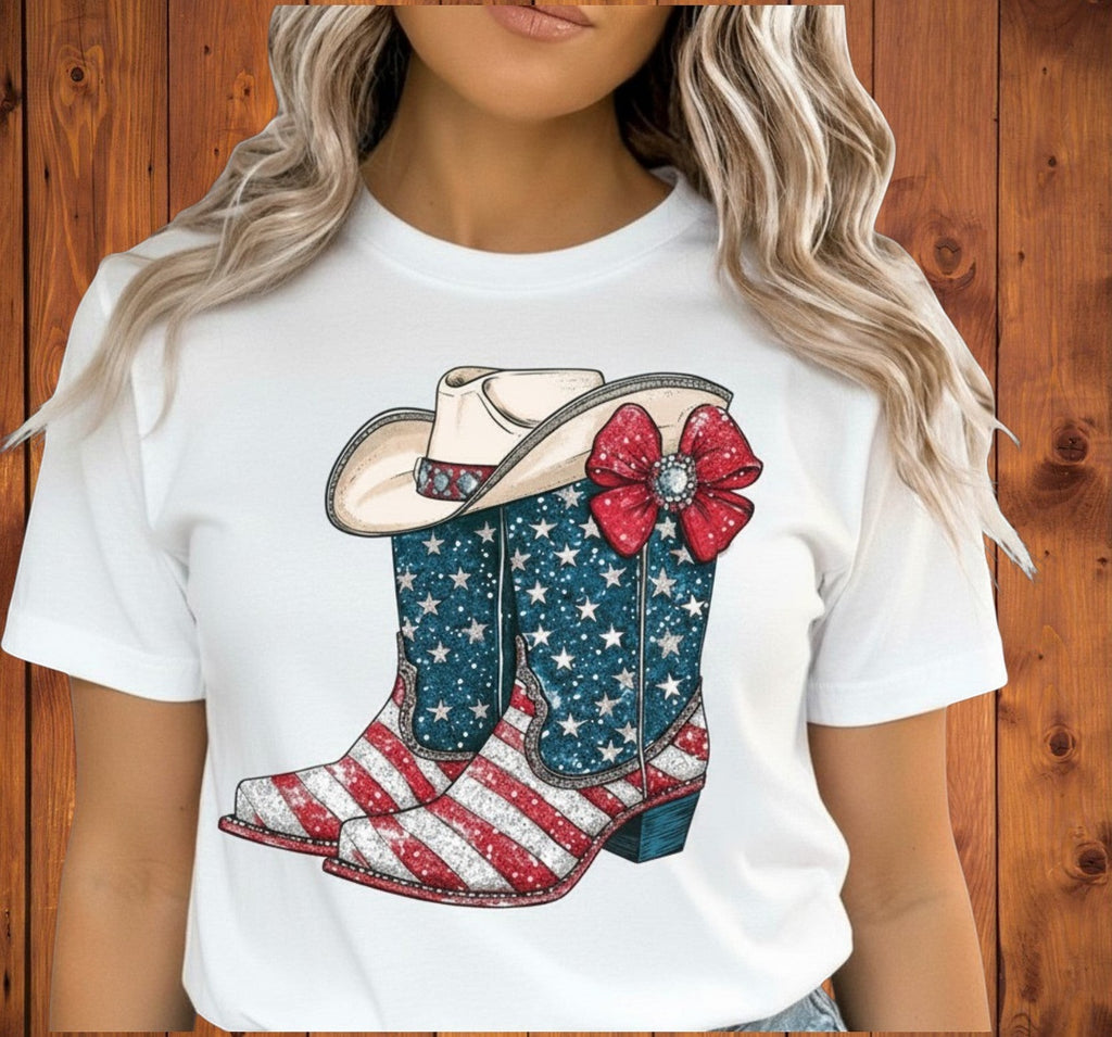 Southern Charm Design Works white t-shirt with patriotic cowboy boots and hat graphic. Boots feature American flag stars and stripes.